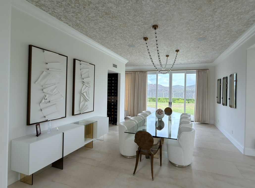 Pelican Ridge, Newport Coast dining room with sculptural lighting, white chairs, and a glass dining table